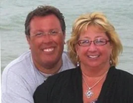 Dr. Mark Kolosionek and Dr. Cara Fawcett, smiling together by the water.